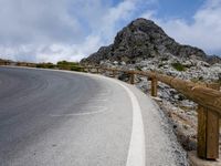 a curved road stretches out into the sky at a distance from the edge of the hill