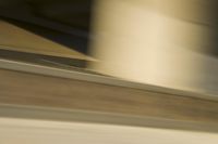 the skateboarder does a trick on a city street corner in motion with the camera panning through