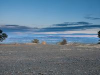 a black fire hydrant in front of a mountainous landscape at sunset on the rim