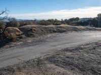 the end of a dirt road in an area that looks to be desert land for a pickup truck