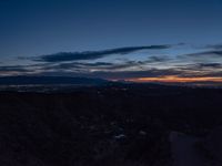 a dark street is shown in the middle of this view at sunset with a mountain below