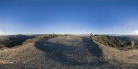 a 360 - lens image shows the trail that goes down the mountains toward the road