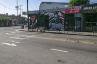 the street is empty and there are no traffic on it at all here, and the buildings are covered in a mural