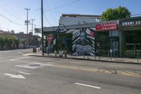 the street is empty and there are no traffic on it at all here, and the buildings are covered in a mural