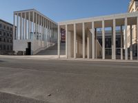 a row of columns is on the street by the building near it on a sunny day