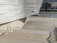 a man that is standing on some stairs in the city with his skateboard and helmet in hand