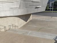 a man that is standing on some stairs in the city with his skateboard and helmet in hand