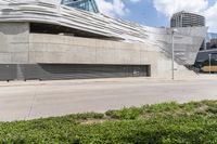 a large gray building with white letters that read museum of contemporary art next to an empty street