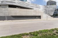 a large gray building with white letters that read museum of contemporary art next to an empty street