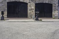 a parking meter on a city sidewalk next to an old brick building with open garage doors