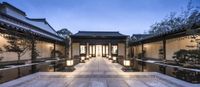 an ornately designed outdoor walkway at night with lanterns and tables lining the sides of each walkway