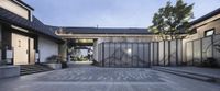 a courtyard area featuring stone and glass panels and plants on the side of the house