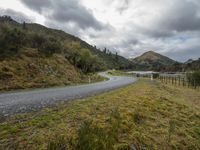 a road leading through an area with a lot of mountains in the background, and a highway is running through the field