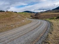 the country road is narrow and empty with rocky corners, and winding road ahead, leading off into mountains