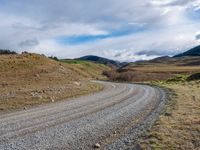 the country road is narrow and empty with rocky corners, and winding road ahead, leading off into mountains