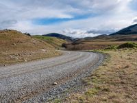 the country road is narrow and empty with rocky corners, and winding road ahead, leading off into mountains