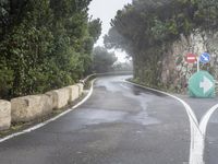 a road that is very narrow with signs on it and a left turn sign next to it