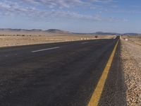 a lone road in the middle of a desert area with no traffic on it on a clear sunny day