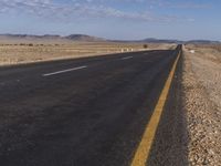 a lone road in the middle of a desert area with no traffic on it on a clear sunny day