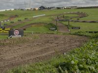 a tractor parked on a hill overlooking a large farm and roadway next to it that is being built