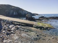 a view of a footpath and bridge near the water in the rocky shoreline of the ocean