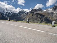 a person on a skate board is sitting on the road with mountains in the background