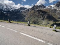 a person on a skate board is sitting on the road with mountains in the background