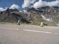 a person on a skate board is sitting on the road with mountains in the background