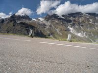 a person on a skate board is sitting on the road with mountains in the background