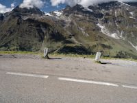 a person on a skate board is sitting on the road with mountains in the background