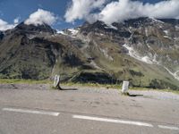 a person on a skate board is sitting on the road with mountains in the background