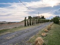 two empty road surrounded by rocks and bushes next to the gravel road that has a small stone walkway