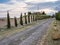 two empty road surrounded by rocks and bushes next to the gravel road that has a small stone walkway