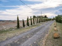 two empty road surrounded by rocks and bushes next to the gravel road that has a small stone walkway