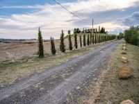 two empty road surrounded by rocks and bushes next to the gravel road that has a small stone walkway