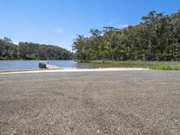 the road leads to an end of a lake where there is a boat on it