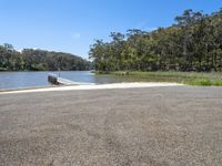 the road leads to an end of a lake where there is a boat on it