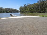 the road leads to an end of a lake where there is a boat on it