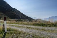 a motorcycle parked on a small mountain side road near mountains with no cars driving on it