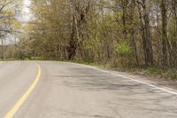 a man is riding a motorcycle down a country road in the countryside area of a state park