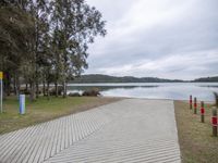 walkway alongside a small body of water with a bench sitting on the bank of it