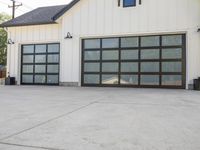 the driveway has an abundance of windows and is concrete and cemented with gray trim