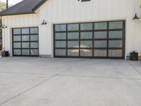 the driveway has an abundance of windows and is concrete and cemented with gray trim