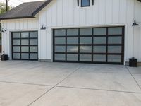 the driveway has an abundance of windows and is concrete and cemented with gray trim