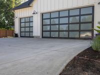 a garage with large windows is shown on concrete floors, and the driveway has wood trim around it