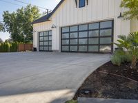 a garage with large windows is shown on concrete floors, and the driveway has wood trim around it