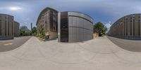 a 360 - lens photograph shows buildings near a street corner with no sidewalks on it