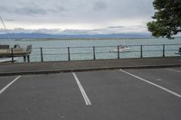 the parking lot at the pier where cars are parked and a bench with a water view