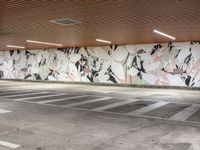 an empty parking lot with painted wallpaper on the walls, and some concrete flooring