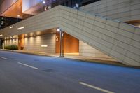 a corner with light posts near the entrance to a building and a ramp in the distance